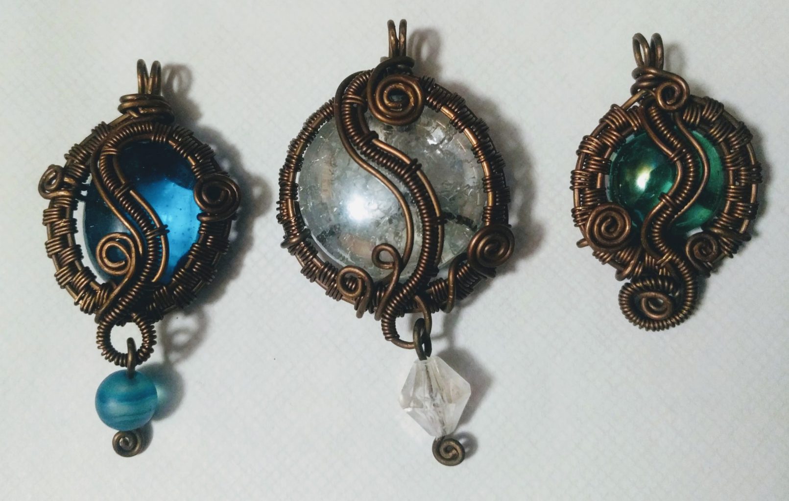 Three copper pendent necklaces with glass beads.